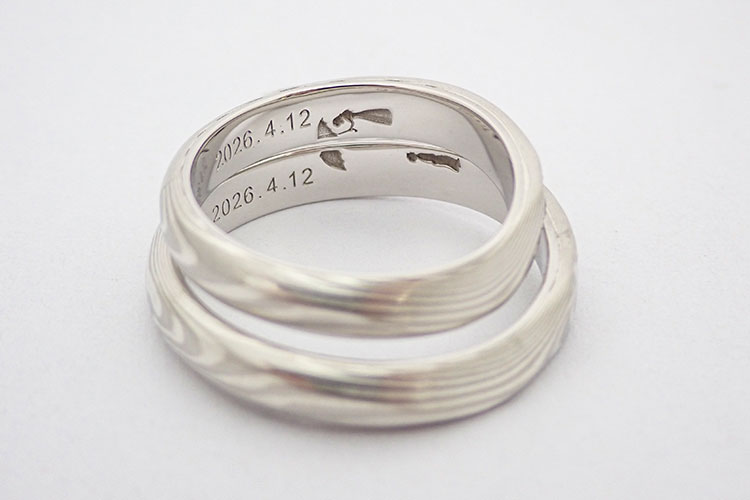 結婚指輪の内側にいれる雨の日に寄り添う傘の刻印